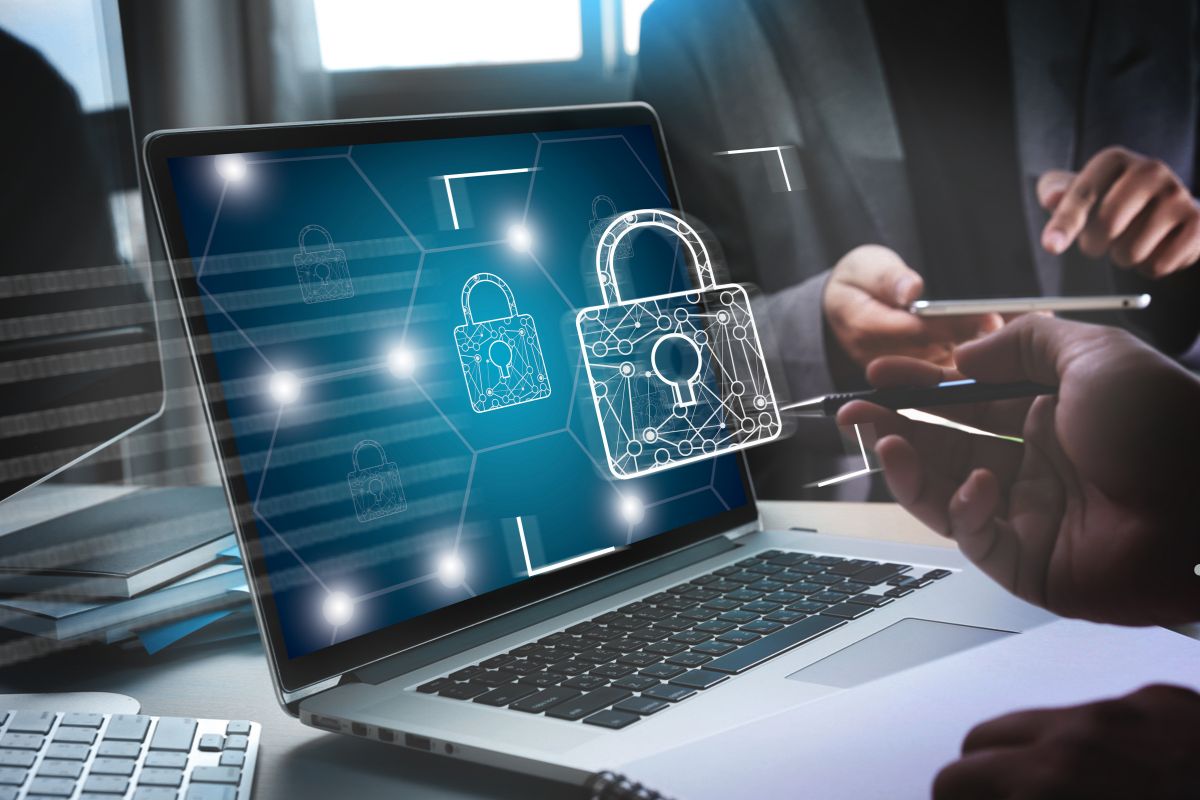 Business professionals collaborating on a laptop, with a prominent security icon displayed on the screen.